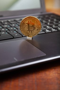 Bitcoin ahşap bir masa üzerinde bir laptop.