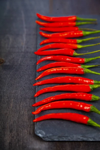 Röd chili pepper är en mörk bakgrund — Stockfoto