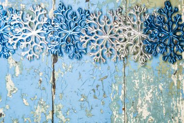 Beyaz kar taneleri mavi eski ahşap arka planda.