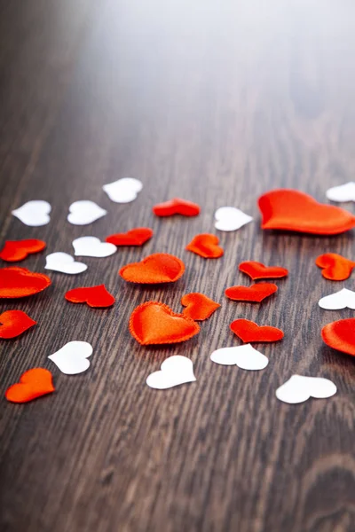 Corazones rojos sobre un fondo de madera. — Foto de Stock