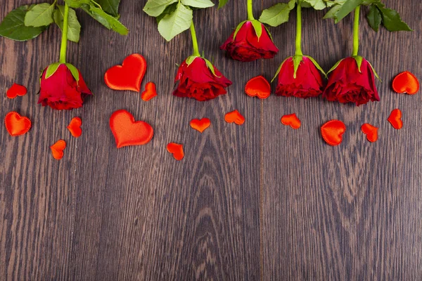 Czerwone róże i serca na tle drewnianych. — Zdjęcie stockowe
