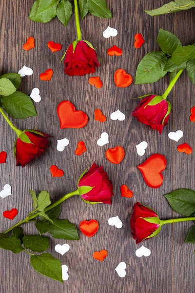 Red roses and hearts on a wooden background. — Stock Photo, Image