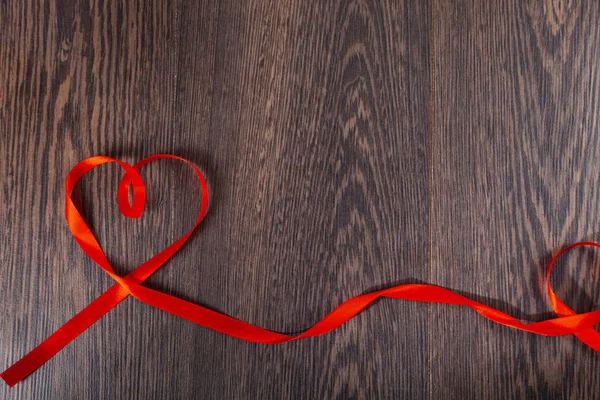 Wstążki w kształcie serca na drewnianym tle. — Zdjęcie stockowe