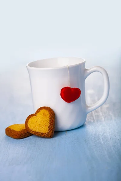 White cup with a heart and cookies. — Stock Photo, Image