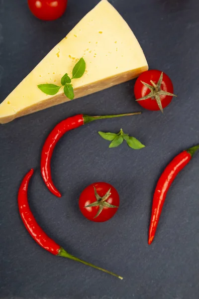 Cheese en chili pepers op een zwarte achtergrond. — Stockfoto