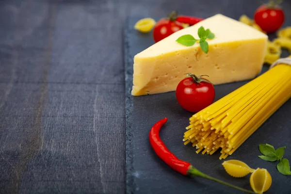 Spaghetti, ost och chilipeppar på en svart bakgrund. — Stockfoto