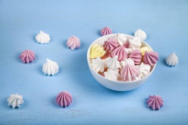 Mavi ahşap arka planda beyaz bir kasede krema.. 