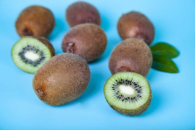 Mavi bir arka plan üzerinde olgunlaşmış kivi