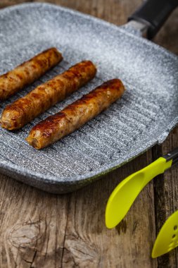 Bir tavada Kupaty, sebze ve baharatlar.