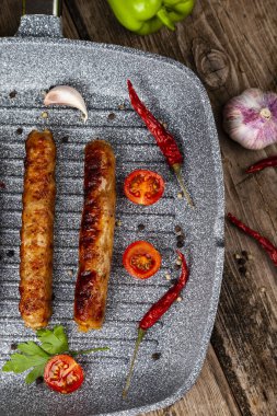 Bir tavada Kupaty, sebze ve baharatlar.