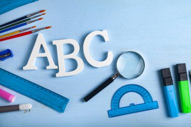 Okula geri dön. Okul için eşyalar ve tahta bir masanın üzerinde Abc harfleri. Metniniz için yer.