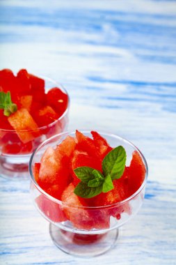 Karpuz ve nane ahşap bir masa üzerinde bir tabak içinde parçalar. Lezzetli tatlı.