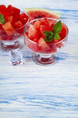 Buzlu karpuz parçaları ve ahşap bir masada bir tabakta nane şekeri. Tatlı nefis..