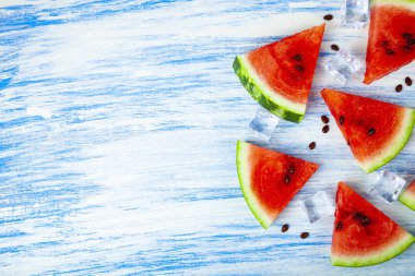 Karpuz ve mavi ahşap bir masa üstten görünüm buza parçalar. Lezzetli tatlı.