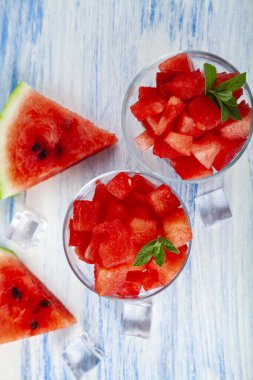 Buzlu karpuz parçaları ve ahşap bir masada bir tabakta nane şekeri. Tatlı nefis..