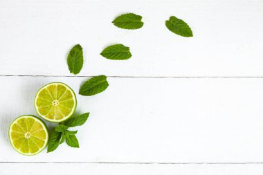 Mavi ahşap bir masada kireç ve nane..