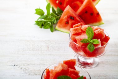 Buzlu karpuz parçaları ve ahşap bir masada bir tabakta nane şekeri. Tatlı nefis..