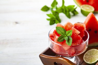 Buzlu karpuz parçaları ve ahşap bir masada bir tabakta nane şekeri. Tatlı nefis..