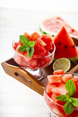 Buzlu karpuz parçaları ve ahşap bir masada bir tabakta nane şekeri. Tatlı nefis..
