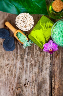 Ahşap arka planda kaplıca aksesuarları ve orkide.