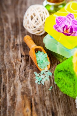 Ahşap arka planda kaplıca aksesuarları ve orkide.