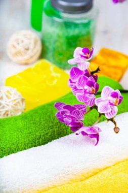 Ahşap arka planda kaplıca aksesuarları ve orkide.