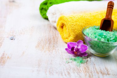 Ahşap arka planda kaplıca aksesuarları ve orkide.