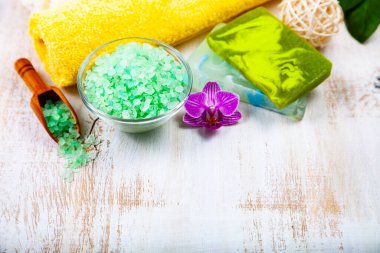 Ahşap arka planda kaplıca aksesuarları ve orkide.