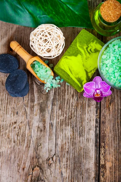 Ahşap arka planda kaplıca aksesuarları ve orkide.