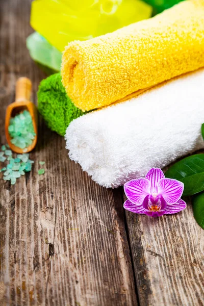 Ahşap arka planda kaplıca aksesuarları ve orkide.