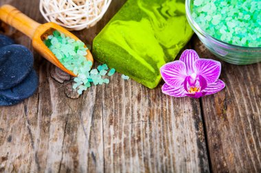 Ahşap arka planda kaplıca aksesuarları ve orkide.