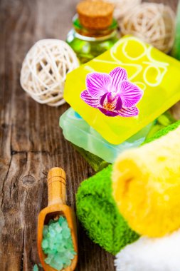 Ahşap arka planda kaplıca aksesuarları ve orkide.