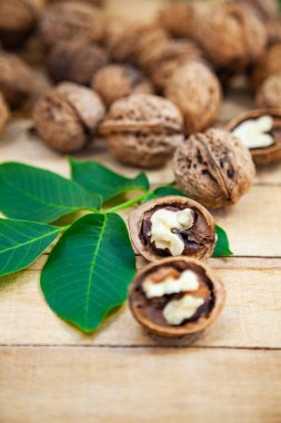 Ceviz ve yapraklar ahşap bir masada.