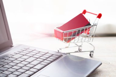 Laptop ve kredi kartıyla alışveriş arabası. İnternetten alışveriş.