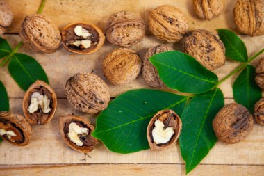 Ceviz ve yapraklar ahşap bir masada.