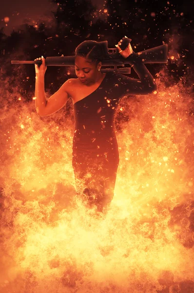 Mulher com espingarda de assalto em chamas — Fotografia de Stock