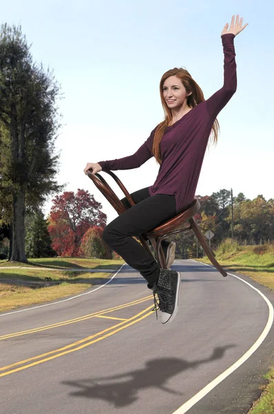 Woman flying in a chair — Stock Photo, Image