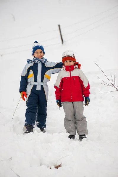 遊び心のある元気な子どもそりや雪で雪だるまを作る — ストック写真