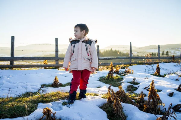 小男孩在雪旁边在木国家篱芭 — 图库照片