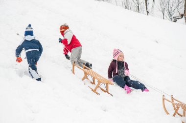 Karda kızakla mutlu oynak çocuk