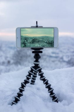 Fotoğrafta City tripod ve smartphone kullanarak kış kar sırasında