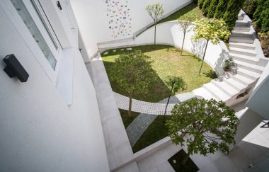 Beyaz villanın önünde güzel bir bahçe.