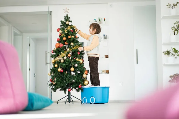 Ragazzo Che Arrampica Sulla Scatola Dei Giocattoli Decorare Albero Natale — Foto Stock