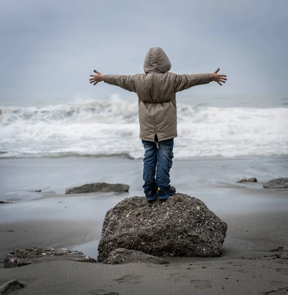 冬の海のビーチを歩く小さな男の子 — ストック写真