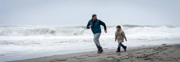 父と息子は冬のビーチで楽しんでいます — ストック写真