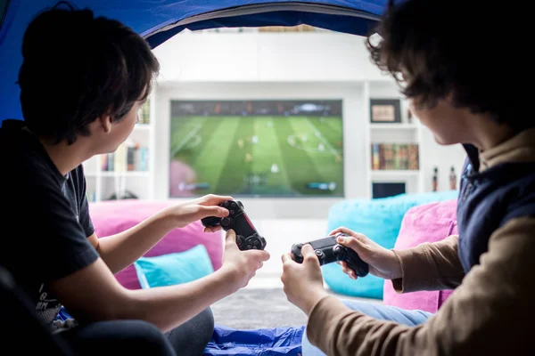 Δύο Αγόρια Που Κάθονται Σκηνή Και Παίζουν Βιντεοπαιχνίδια Στην Κονσόλα — Φωτογραφία Αρχείου