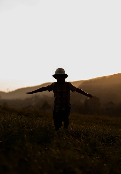 日落时分 男孩在土地上的轮廓 — 图库照片
