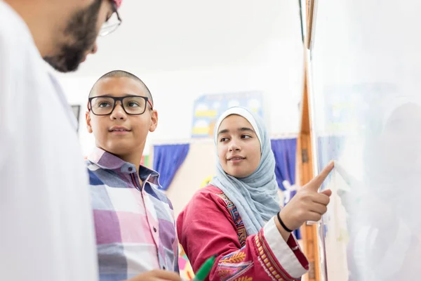 Studenti Arabi Musulmani Risolvono Una Domanda Matematica Sulla Lavagna Fotografia Stock