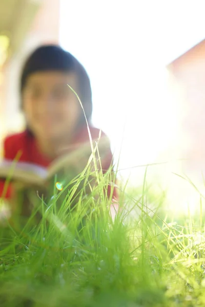 Kind leest een boek over zonnig weiland — Stockfoto