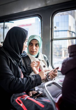 Anne ve kızı şehirde toplu taşıma araçlarına biniyor.